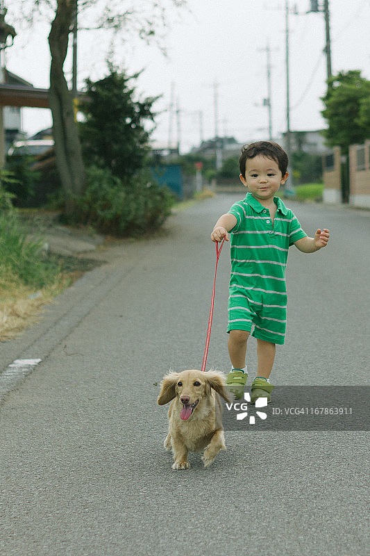 带着狗在路上奔跑的男孩图片素材