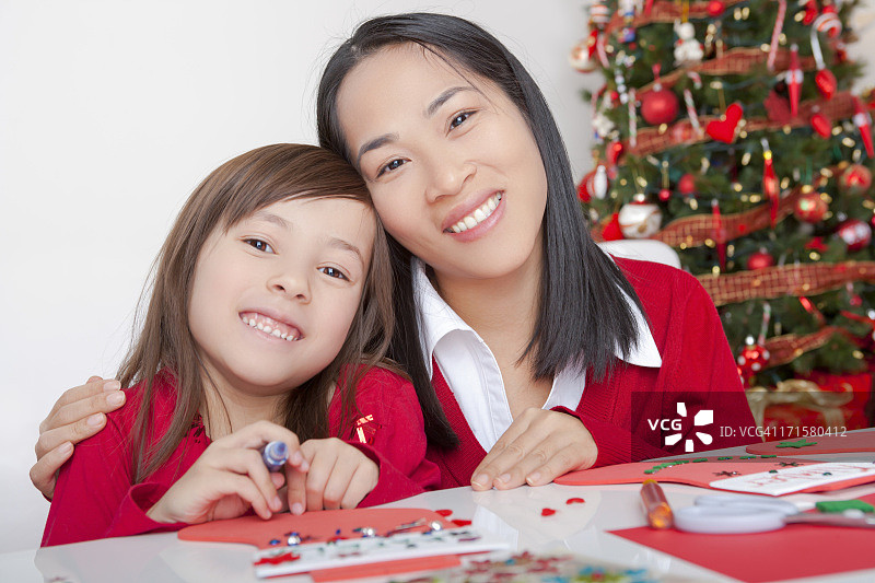 亚洲母亲和女儿制作圣诞卡片图片素材