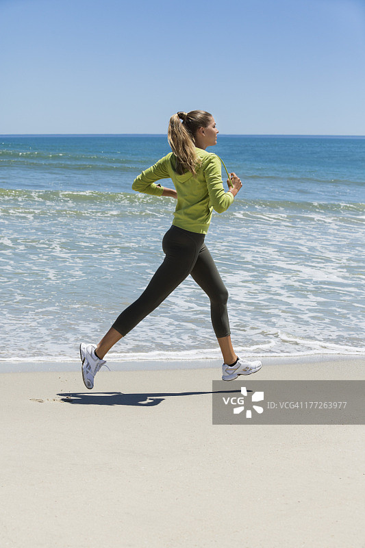 在海滩上慢跑的女人图片素材