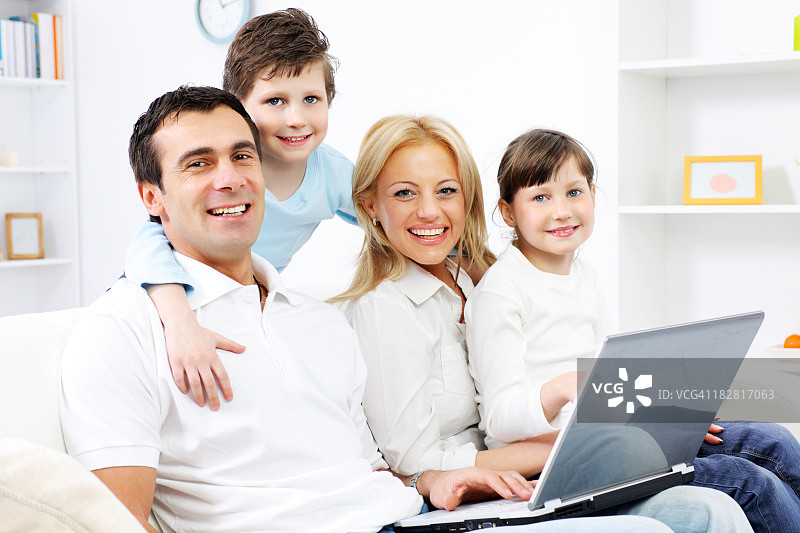 幸福的家庭和笔记本电脑。图片素材