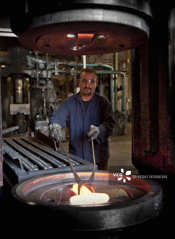 钢铁工人用钳子操纵金属图片素材