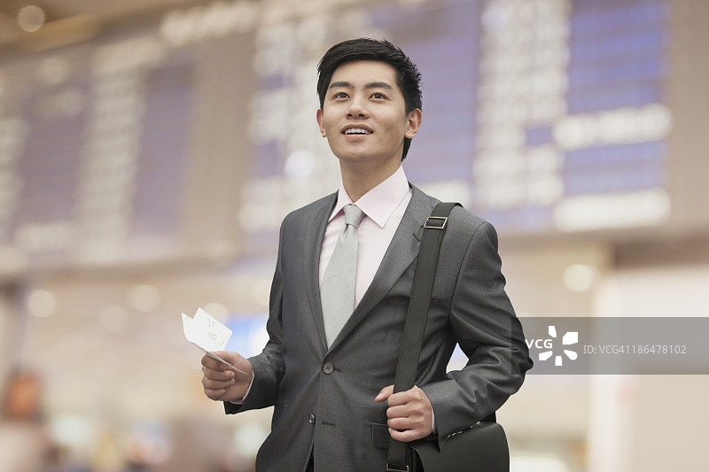 年轻的商人拿着机票在机场，北京，中国图片素材