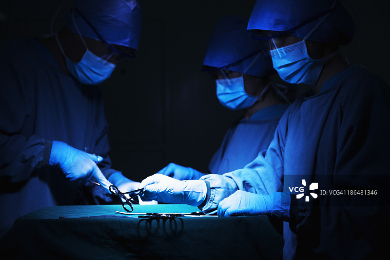 一组外科医生拿着手术设备在手术台上工作图片素材