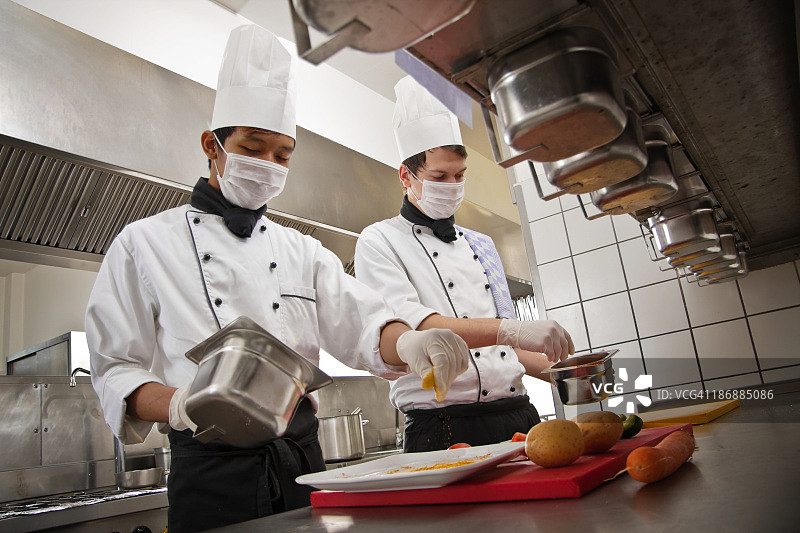 厨师和实习生在酒店厨房准备一顿饭图片素材
