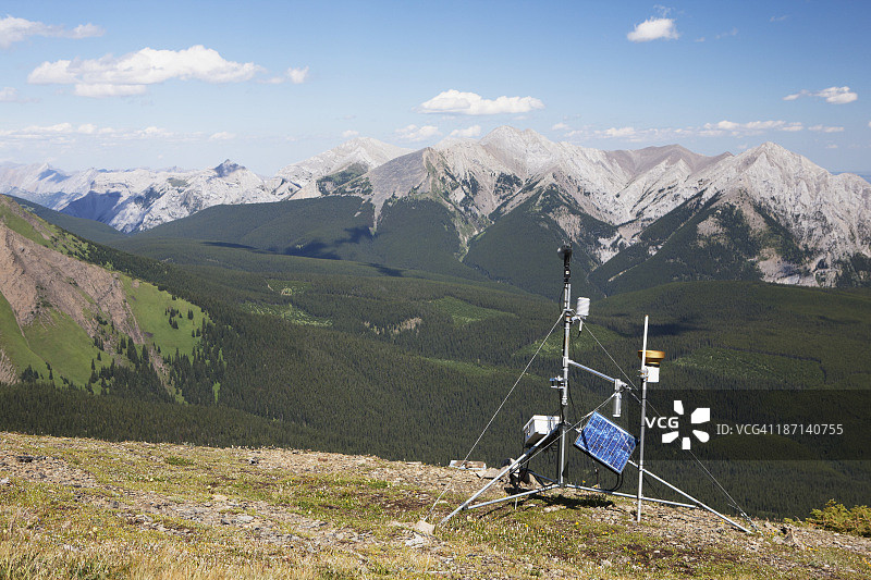 一个位于山脊上的气象站，远处有高山和山谷，蓝天白云图片素材