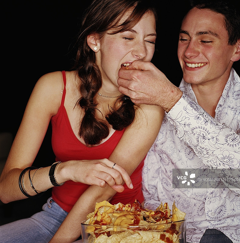青少年情侣(15-18岁)在吃玉米片图片素材