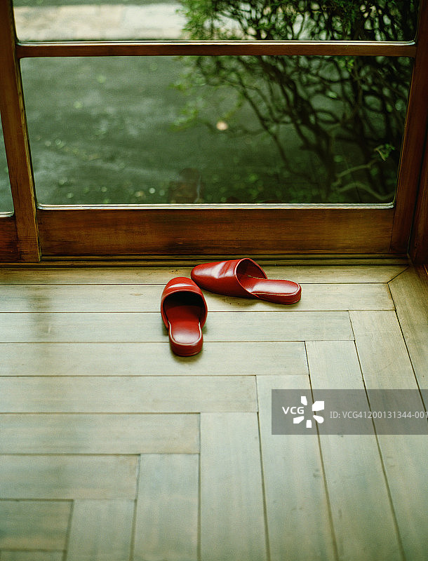 靠近窗户的红色拖鞋图片素材