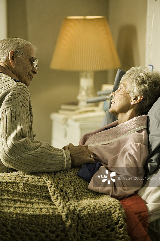 在养老院里，一位老人和一位生病的老妇人坐在床上图片素材