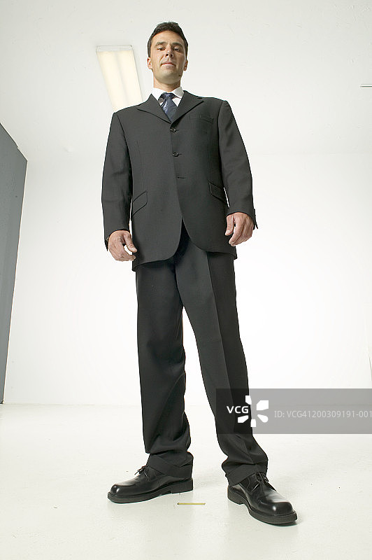 男子身穿黑衣，在演播室摆姿势，人像，低角度视角图片素材