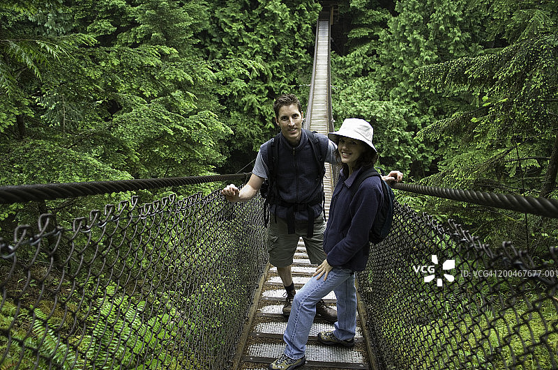 男人和女人站在森林的吊桥上，肖像图片素材