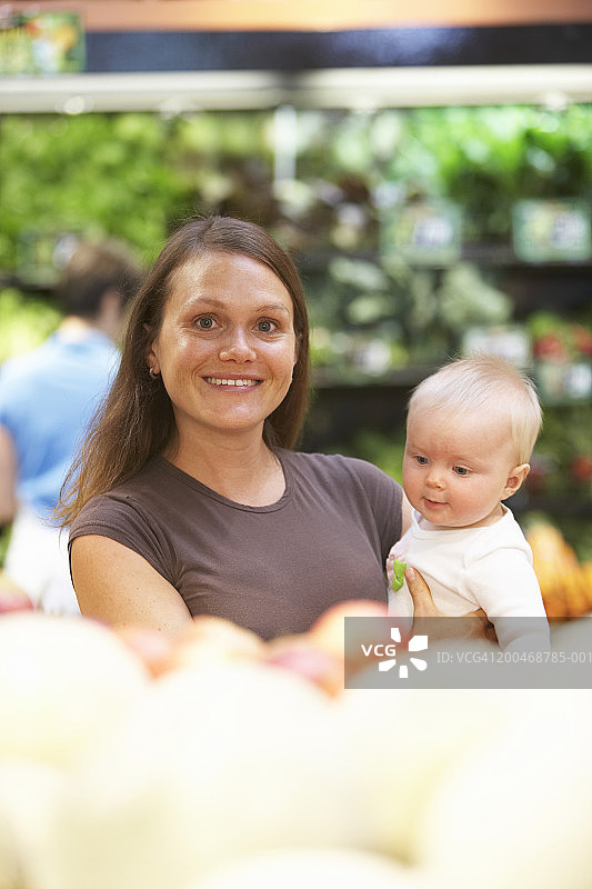 母亲和女婴(6-9个月)在超市农产品区图片素材
