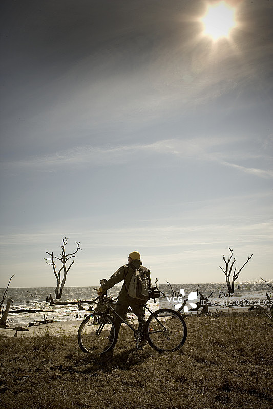 男性徒步者与山地自行车在公牛岛，后视图图片素材