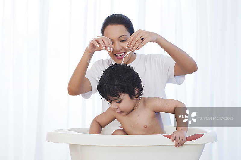 一位妇女正在给儿子洗澡图片素材