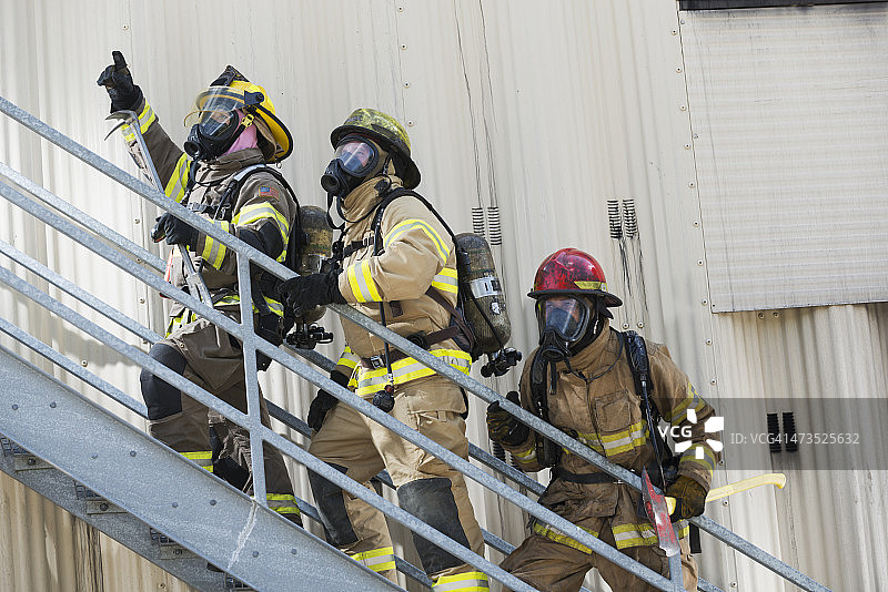 消防队员在工业大楼外爬楼梯图片素材