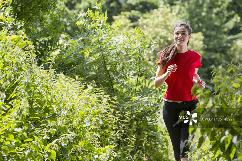 女子慢跑穿过森林图片素材