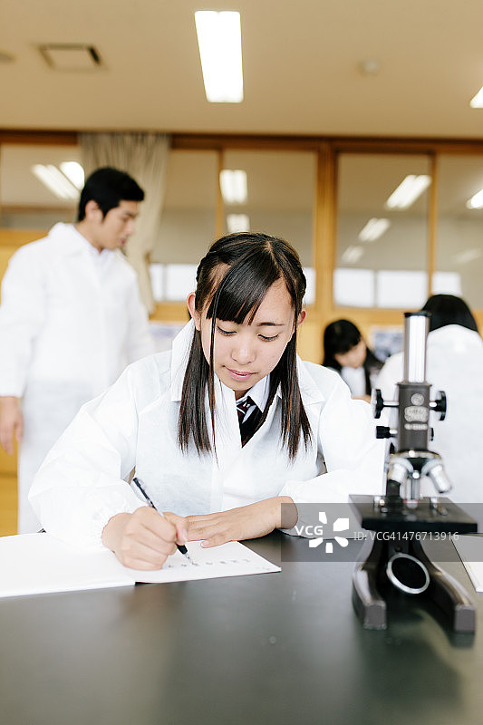 日本的高中。学生学习，科学实验室，长凳上的显微镜图片素材