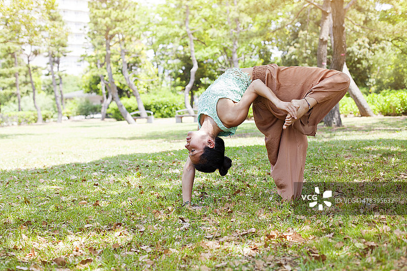 年轻的亚洲女子在东京公园练习瑜伽。图片素材
