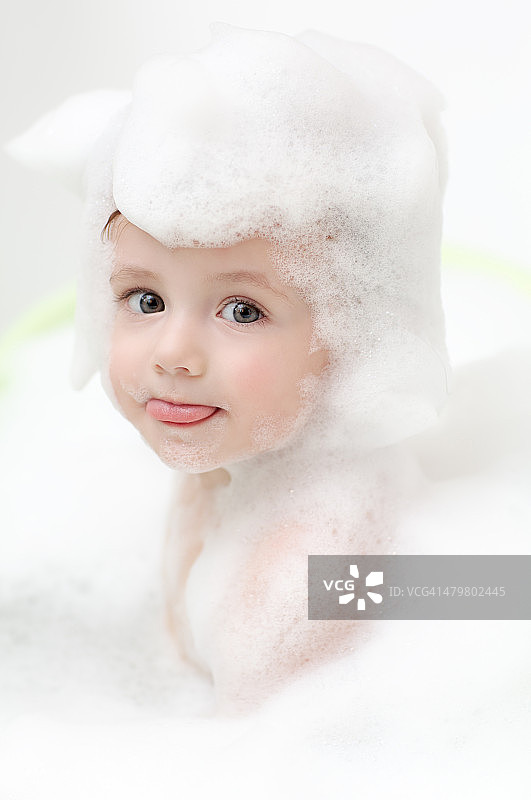可爱的宝宝在浴缸里伸出舌头图片素材