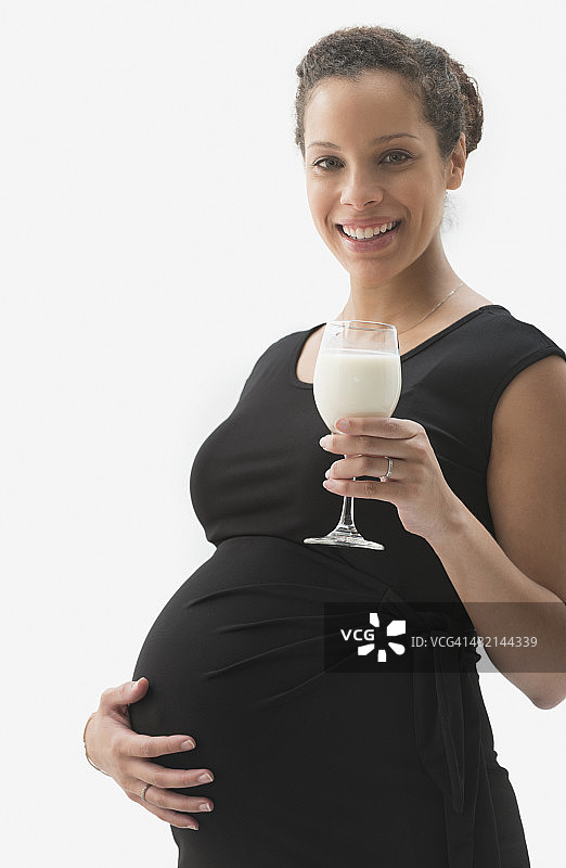 混血孕妇喝牛奶的肖像图片素材