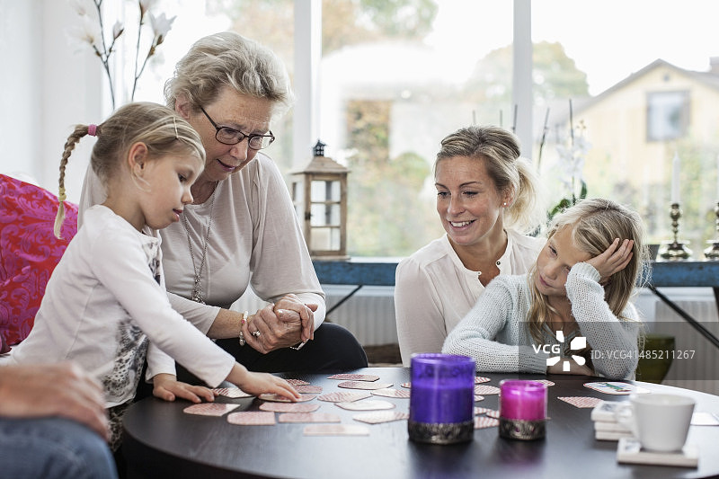 三代女性在家玩拼图游戏图片素材