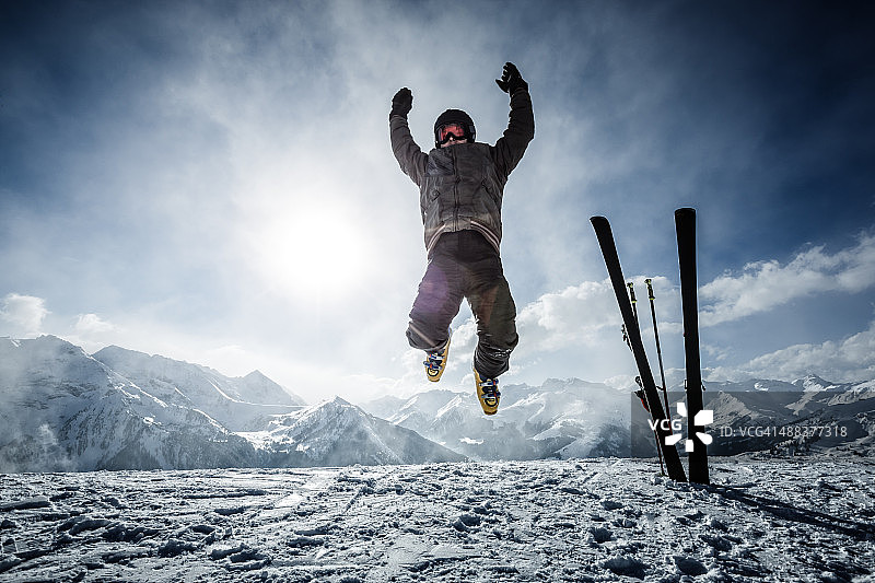快乐的高山滑雪者在顶部的空中跳跃图片素材