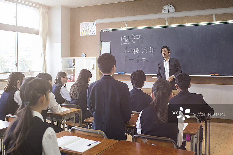 一个日本学生站着回答老师的问题图片素材