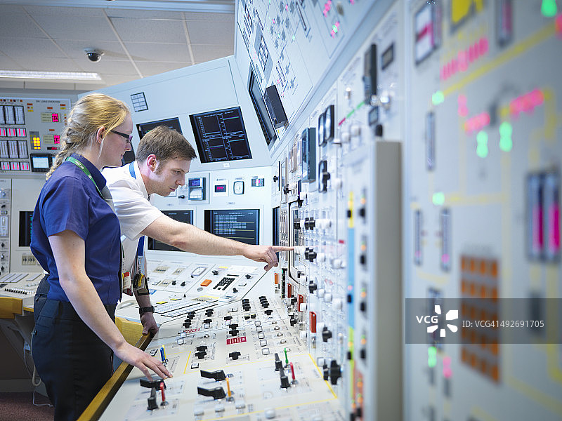 核电站控制室模拟器中的女操作员和学员图片素材