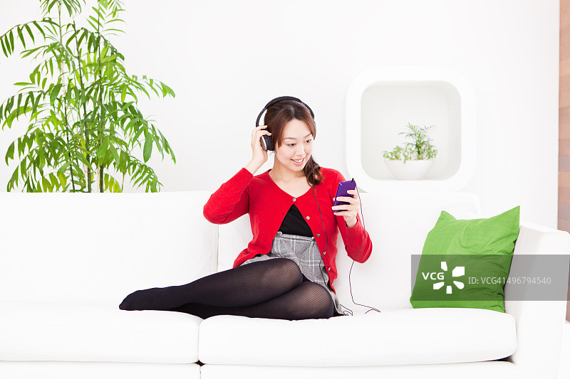 年轻的日本女子用耳机听音乐图片素材