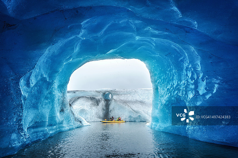 蓝色洞穴里的皮艇。图片素材