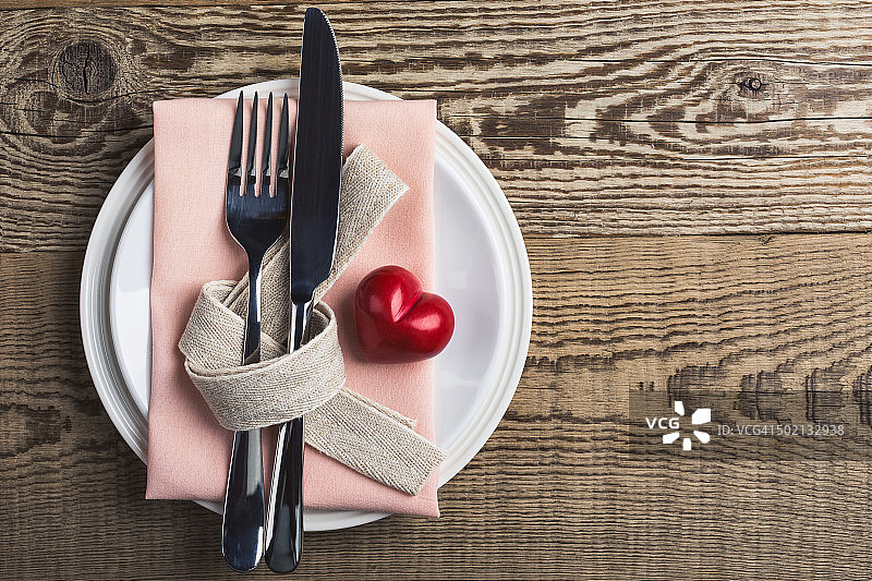 情人节餐桌布置刀，叉，丝带和心形，俯视图图片素材