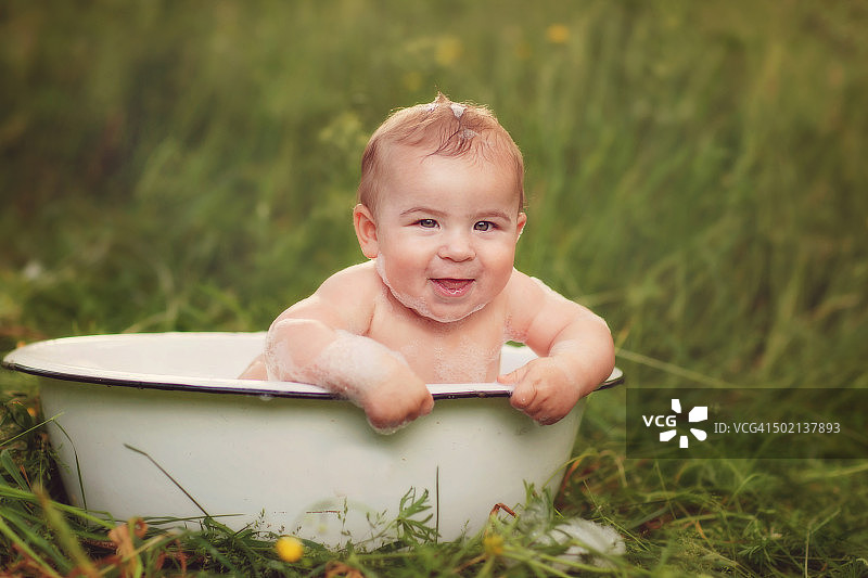 快乐的宝宝在户外洗泡泡浴图片素材