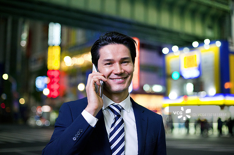 日本商人晚上在东京涉谷打电话图片素材