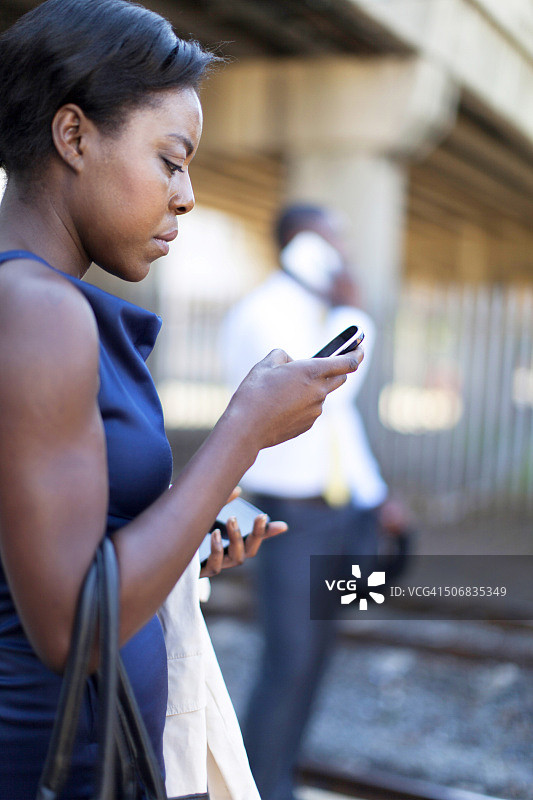 南非开普敦，一名非洲女商人在火车站起诉自己的手机图片素材