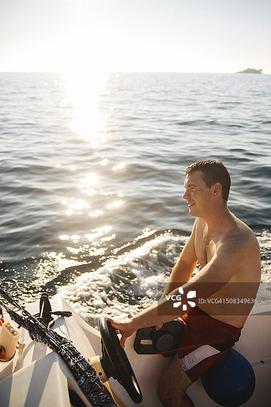 一个年轻人驾着快艇享受夏日图片素材