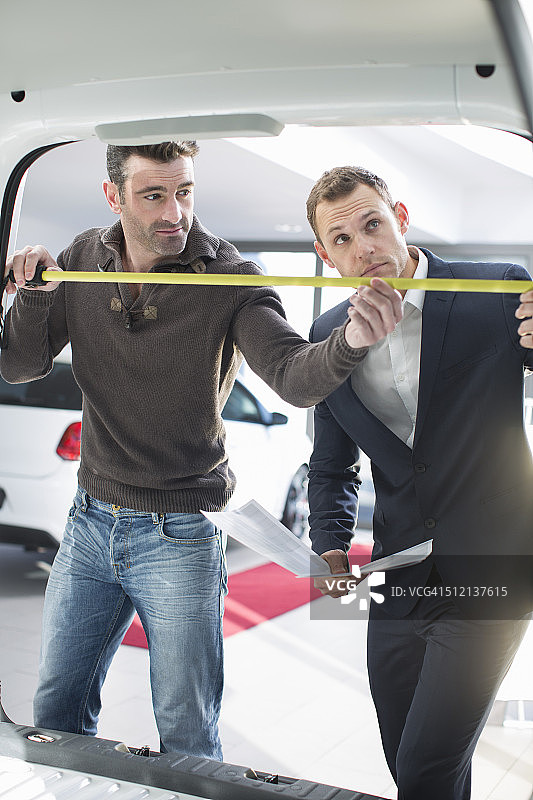 客户和销售人员在汽车经销商测量货车内饰图片素材