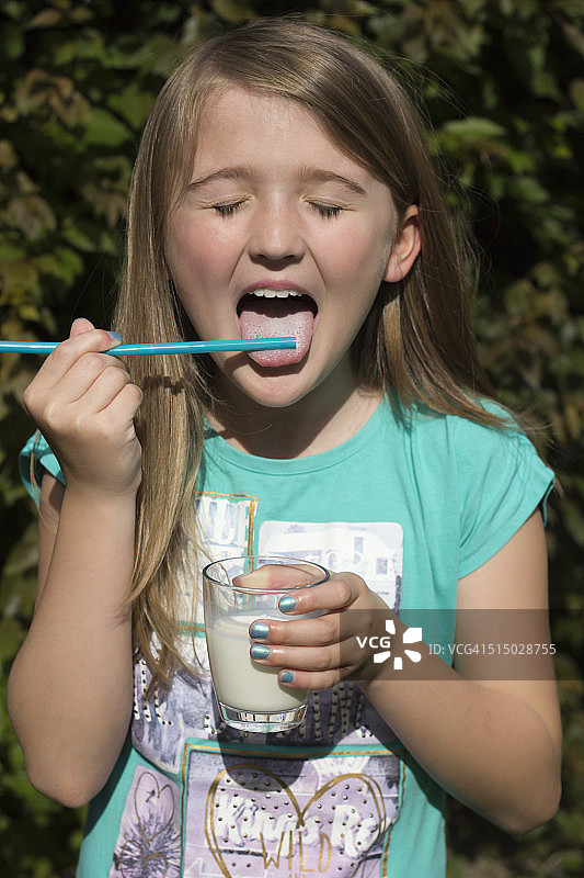 女孩用吸管舔牛奶的画像图片素材