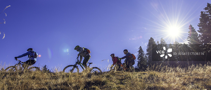 四个骑自行车的人在山顶上骑他们的自行车图片素材