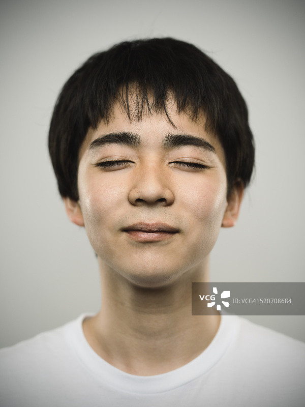 一个闭着眼睛的日本少年的肖像。图片素材