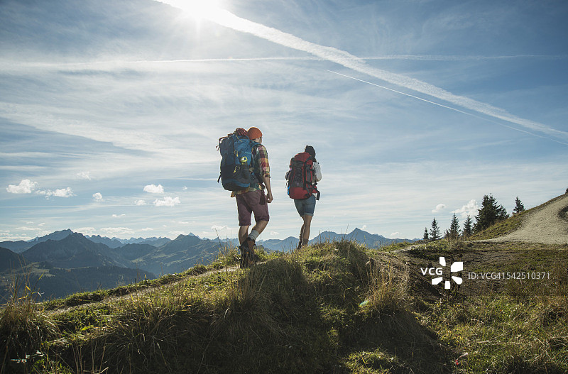 奥地利，蒂罗尔，坦海默·塔尔，一对在山间徒步旅行的年轻夫妇图片素材