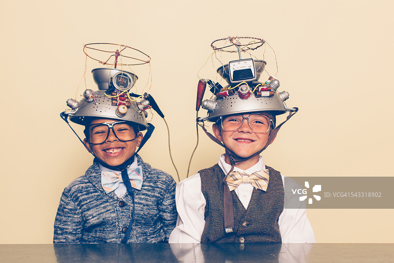 两个男孩装扮成书呆子微笑着戴着读心术头盔图片素材