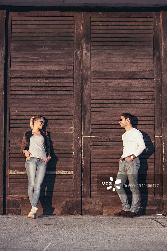 一对年轻夫妇靠在木门上图片素材