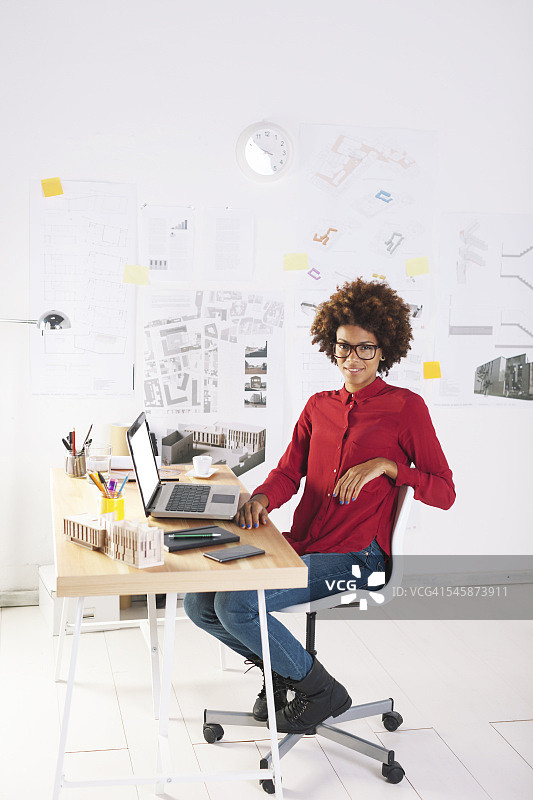 年轻的女建筑师，桌上放着笔记本电脑图片素材