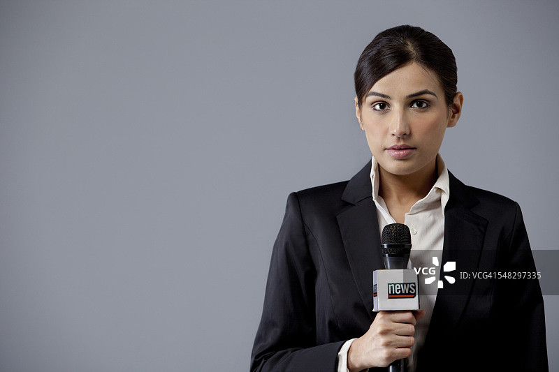彩色背景下的年轻女新闻播音员肖像图片素材