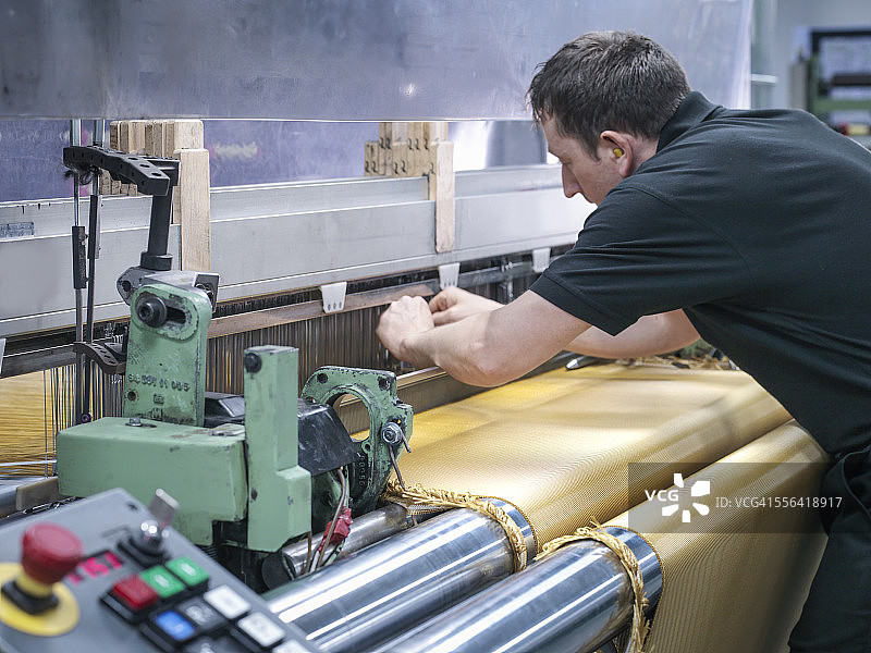 在碳纤维工厂编织凯夫拉纤维织物的工人图片素材