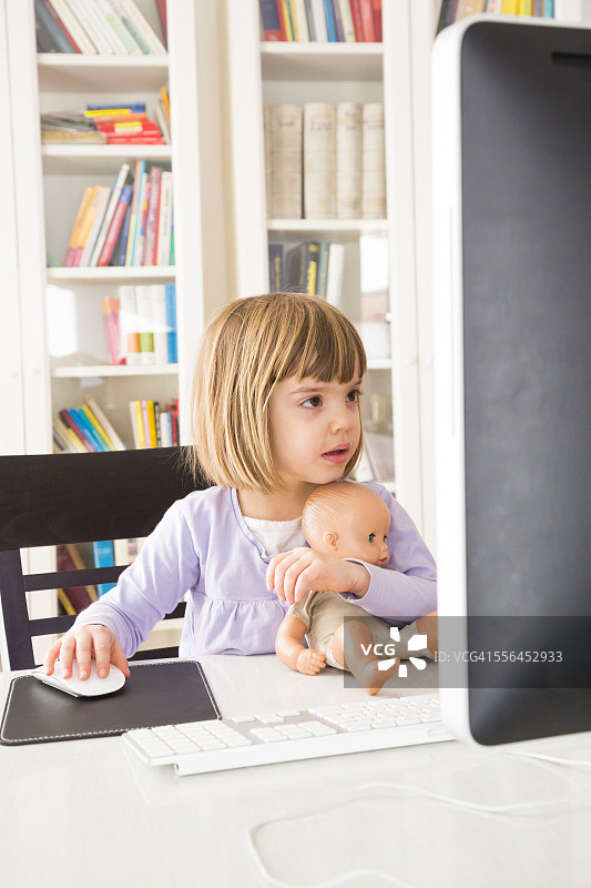 小女孩的肖像与娃娃花时间在电脑图片素材