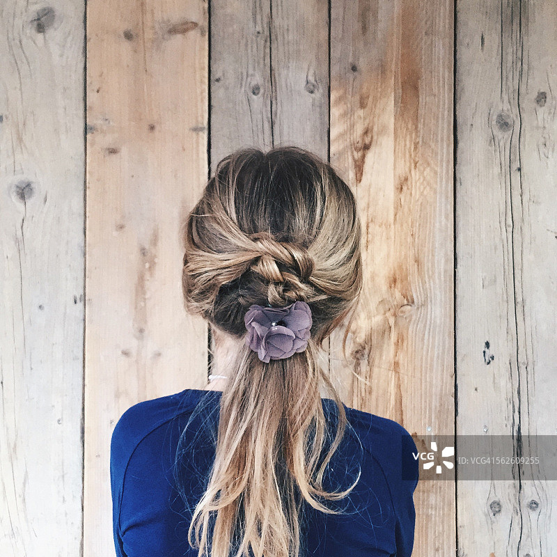 一个头发上插着花的女孩的后视图图片素材