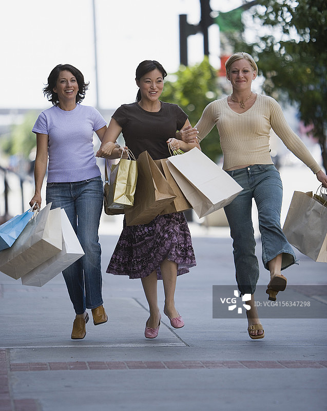 三个拎着购物袋的女人图片素材