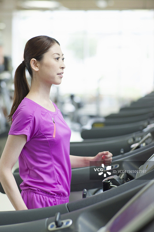 在健身房跑步机上跑步的女人图片素材
