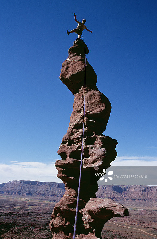 一个人站在岩石顶部的低角度视图图片素材