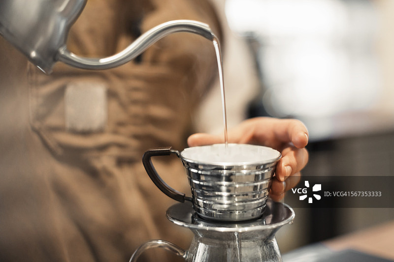 咖啡师在咖啡杯里倒水的裁剪图像图片素材